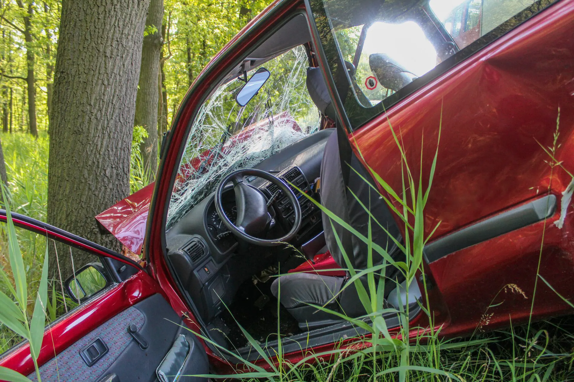 Red car with accident damage to the door and body panels