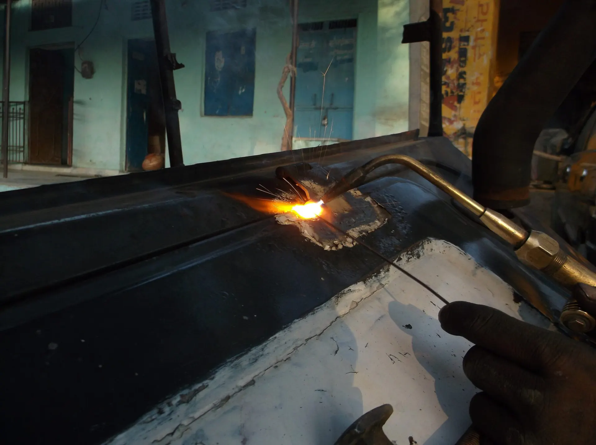 Technician heating and shaping a metal car body panel