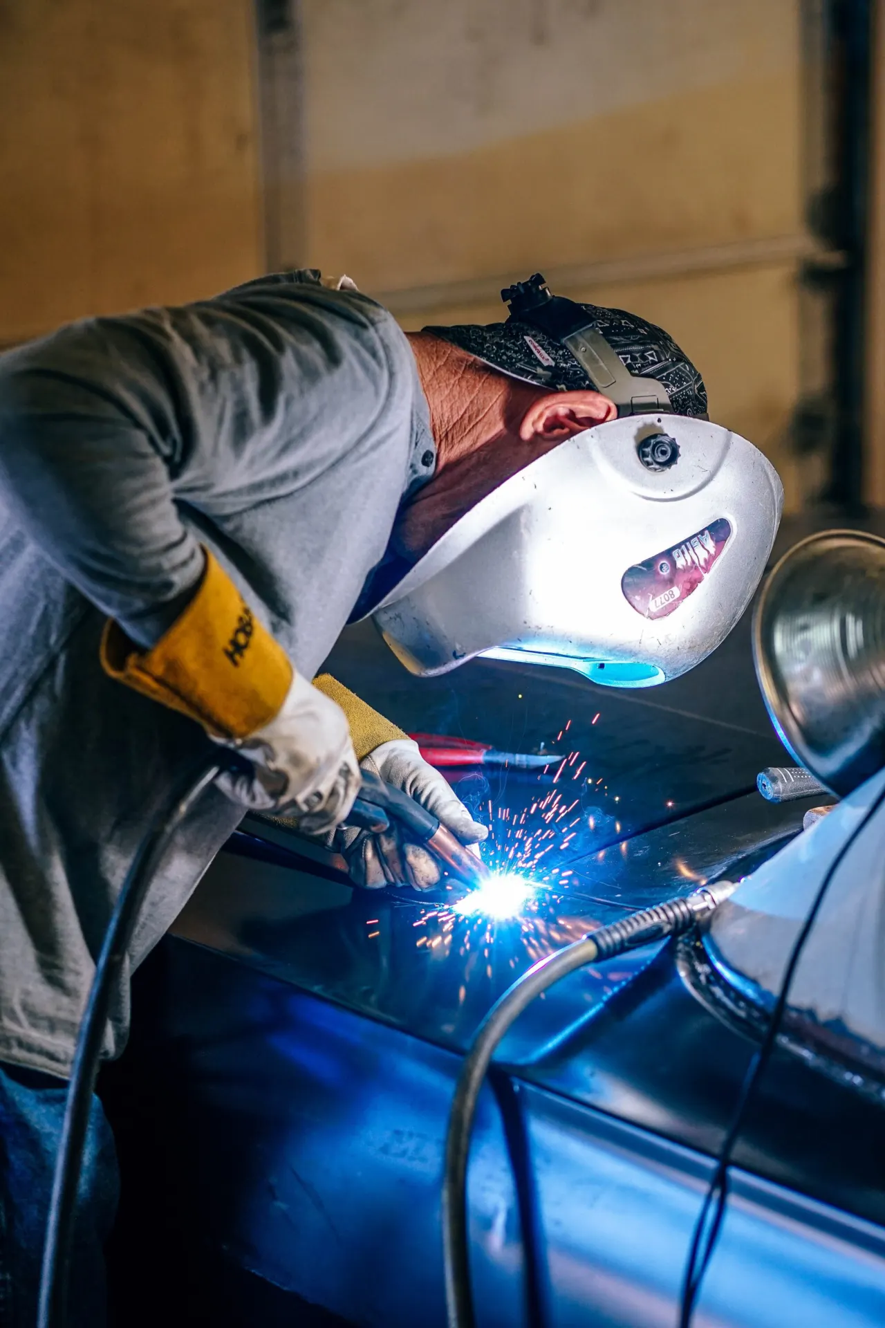 Automotive welding on a car body panel with bright sparks
