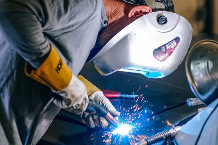 Automotive welding on a car body panel with bright sparks